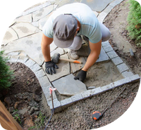 Image of an
        employee laying some garden stonework